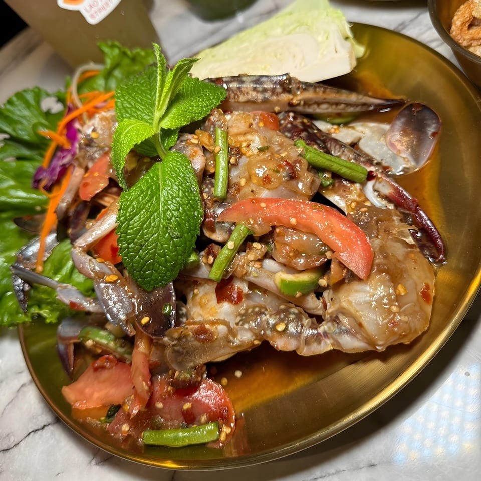 So Saap's spicy Thai blue crab salad with tomatoes, green beans, and mint on a gold plate.